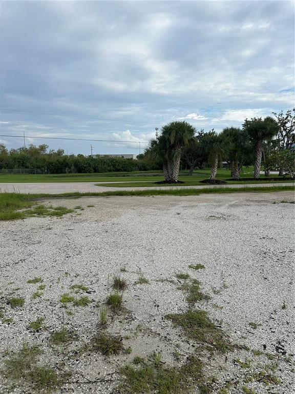 An expansive, gravel-covered vacant lot features a few palm trees under a cloudy sky — 4362 KERRIGAN CIRCLE, PORT CHARLOTTE, FL