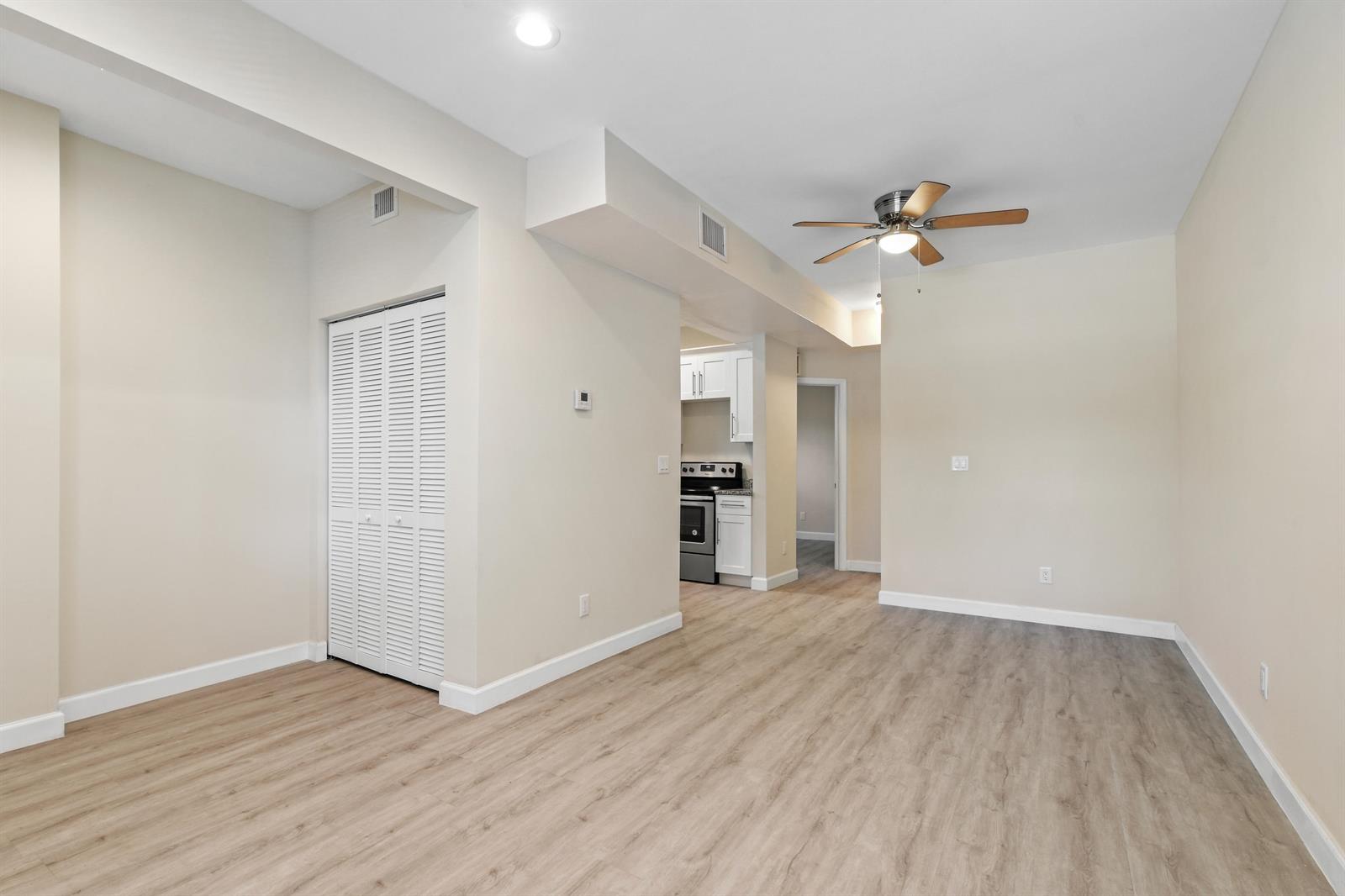 An empty room with light wood-look flooring, a ceiling fan, and a white closet door — 627 Bunker Road, West Palm Beach FL 33405, WEST PALM BEACH, FL