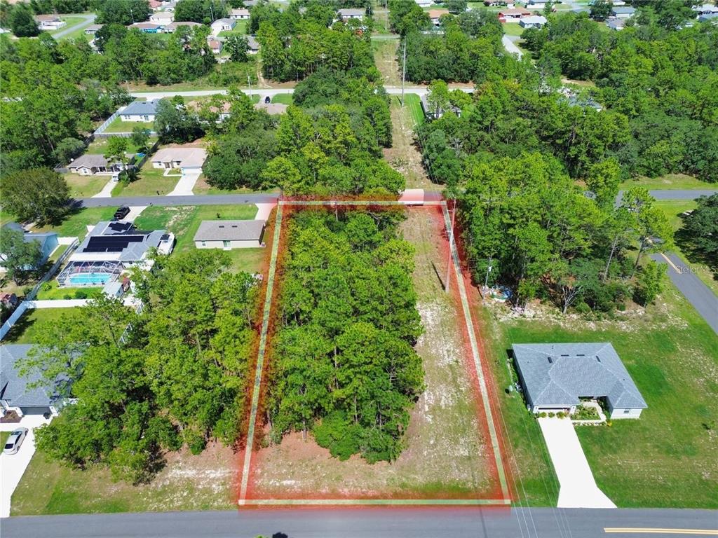 An aerial view shows a rectangular, partially wooded vacant lot outlined in red — TBD SW 50TH COURT RD, OCALA, FL