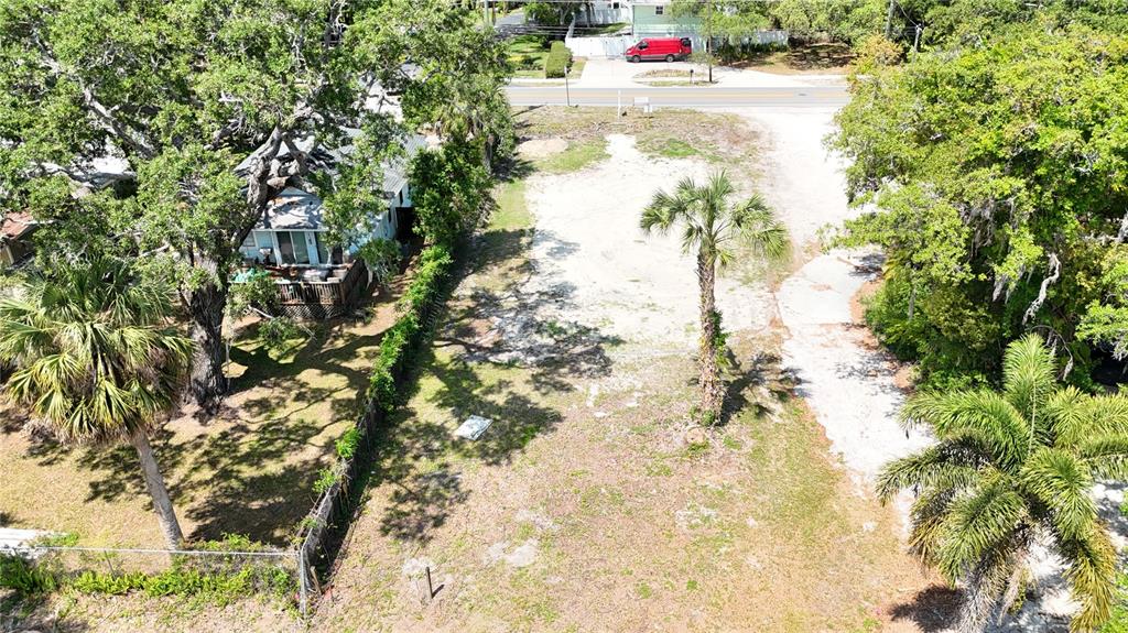 An aerial view shows a vacant, sandy lot situated between two houses and a road — 290 ORANGE STREET, PALM HARBOR, FL