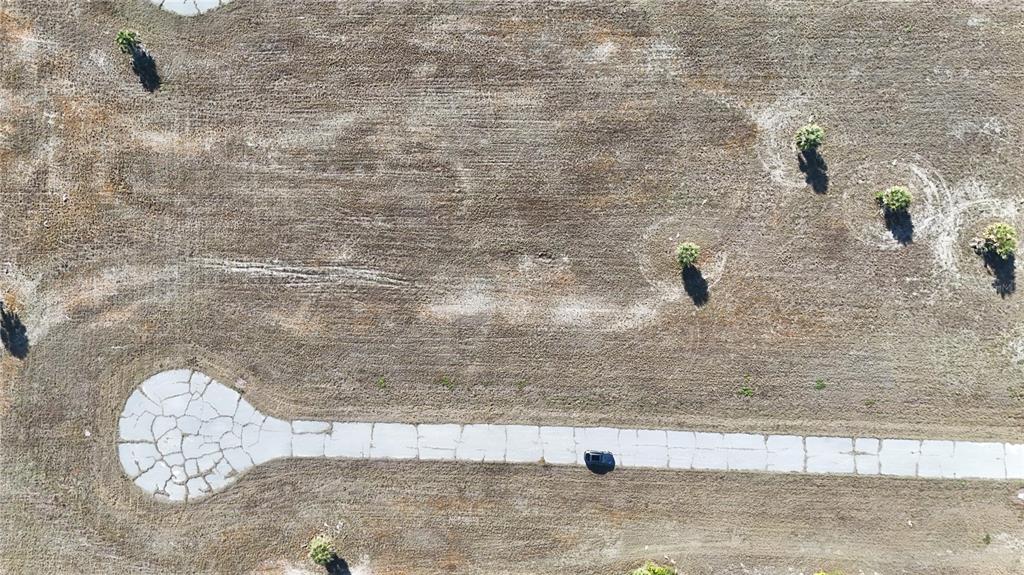 An aerial view shows a paved cul-de-sac and driveway surrounded by a large, undeveloped lot — 14381 SWORDFISH COURT, PLACIDA, FL