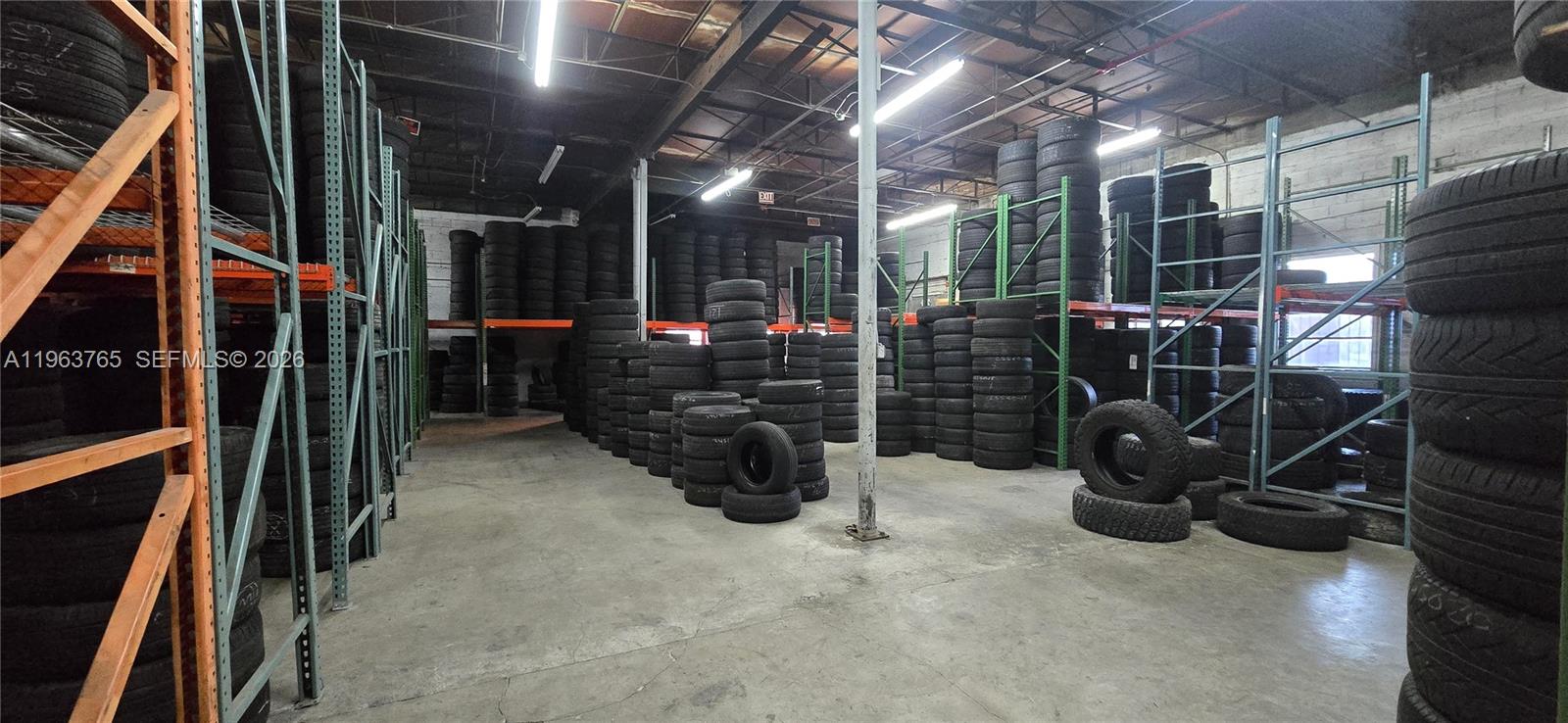 A warehouse interior features tall metal shelving units filled with stacks of tires — 0000 NW 00th Ct, Hialeah FL 33142, HIALEAH, FL