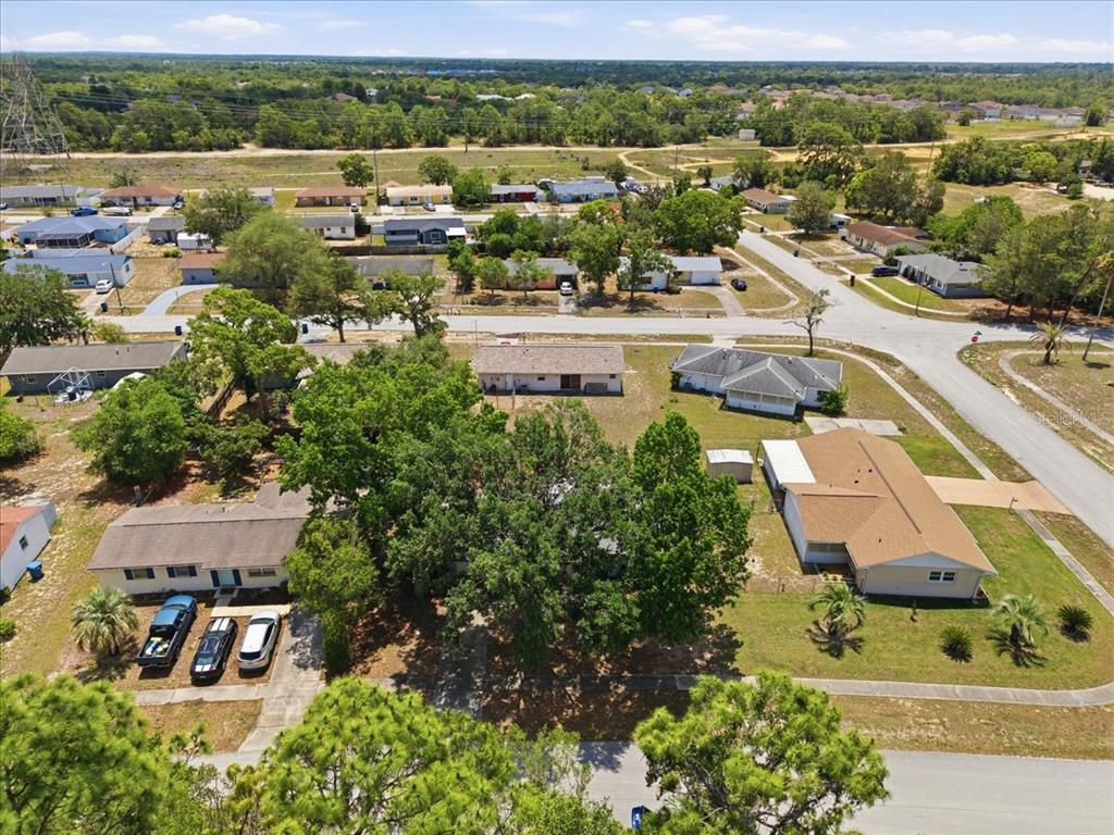 An aerial view of a suburban neighborhood featuring several single-story houses and mature trees — 12452 EDDINGTON ROAD, SPRING HILL, FL
