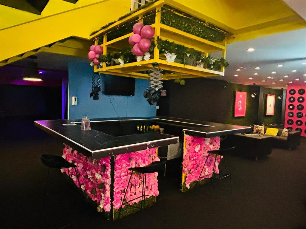 A bar area features a black countertop, floral-covered base, and a yellow overhead hanging structure — C. Isabel-Muñoz Rivera C. ISABEL-MUÑOZ RIVERA, PONCE, PR