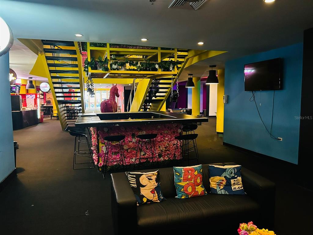 A lounge area features a bar with a floral base, black stools, and a black sofa — C. Isabel-Muñoz Rivera C. ISABEL-MUÑOZ RIVERA, PONCE, PR