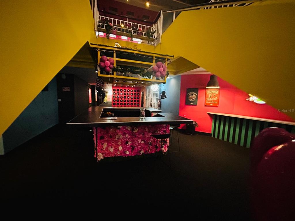 A bar area features a floral-covered counter, yellow walls, and a lofted seating level above — C. Isabel-Muñoz Rivera C. ISABEL-MUÑOZ RIVERA, PONCE, PR