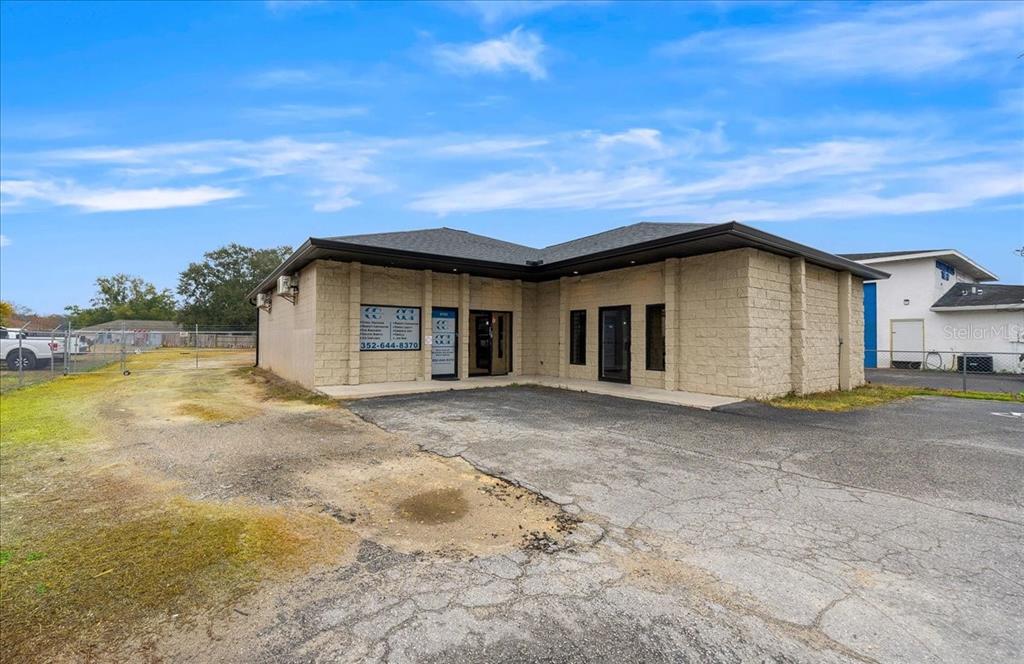A single-story commercial building with tan block walls and a paved parking lot — 2733 SE 58TH AVENUE, OCALA, FL