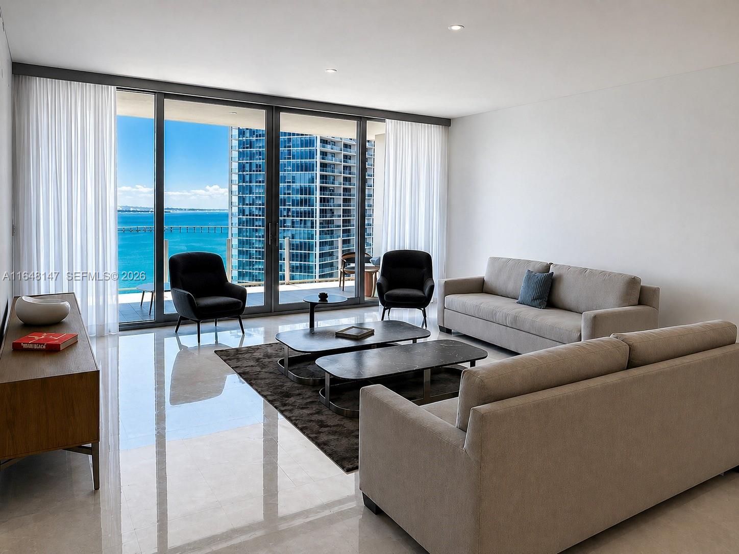 A modern living room features two sofas, dark armchairs, marble coffee tables, and floor-to-ceiling windows — 300 Biscayne Blvd Way # 4604, Miami FL 33131, MIAMI, FL
