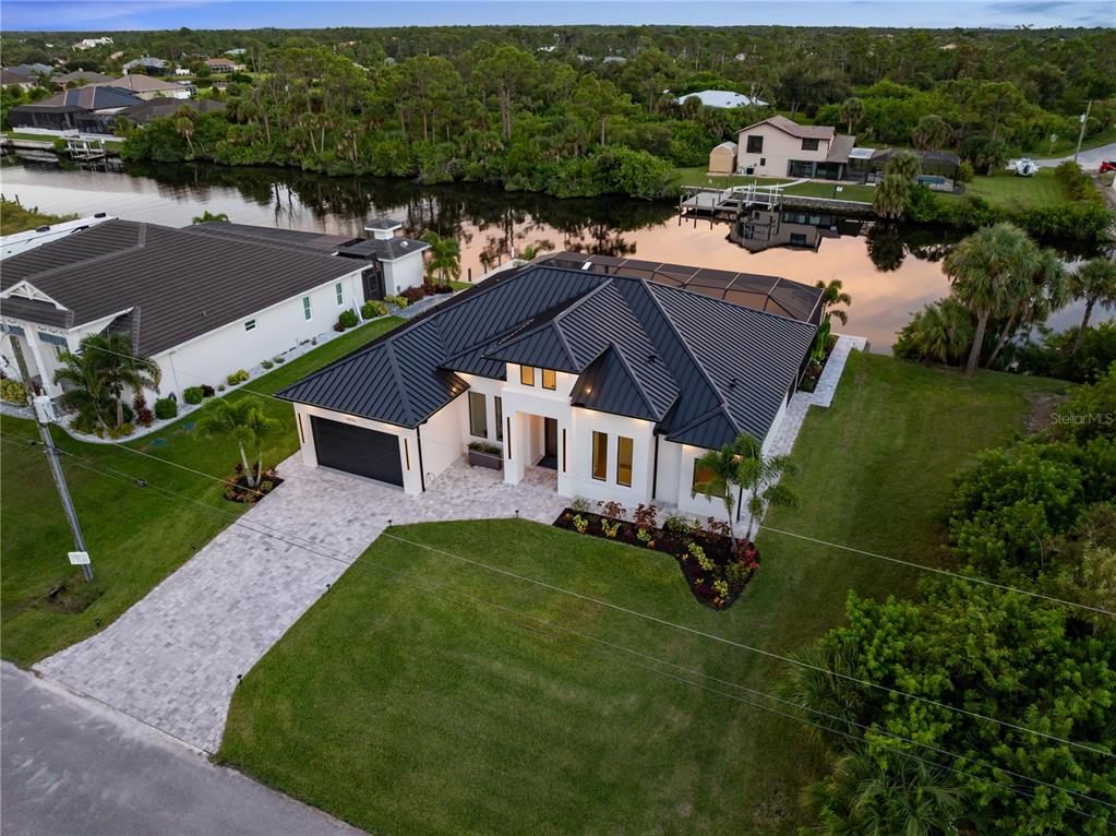 An aerial view of a modern single-story house with a black metal roof and pool — 13125 IRWIN DRIVE, PORT CHARLOTTE, FL