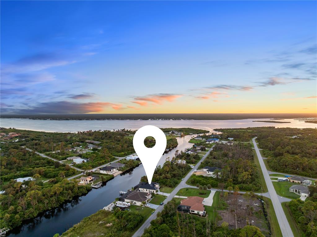 An aerial view shows a house with a pin marker located along a canal — 13125 IRWIN DRIVE, PORT CHARLOTTE, FL