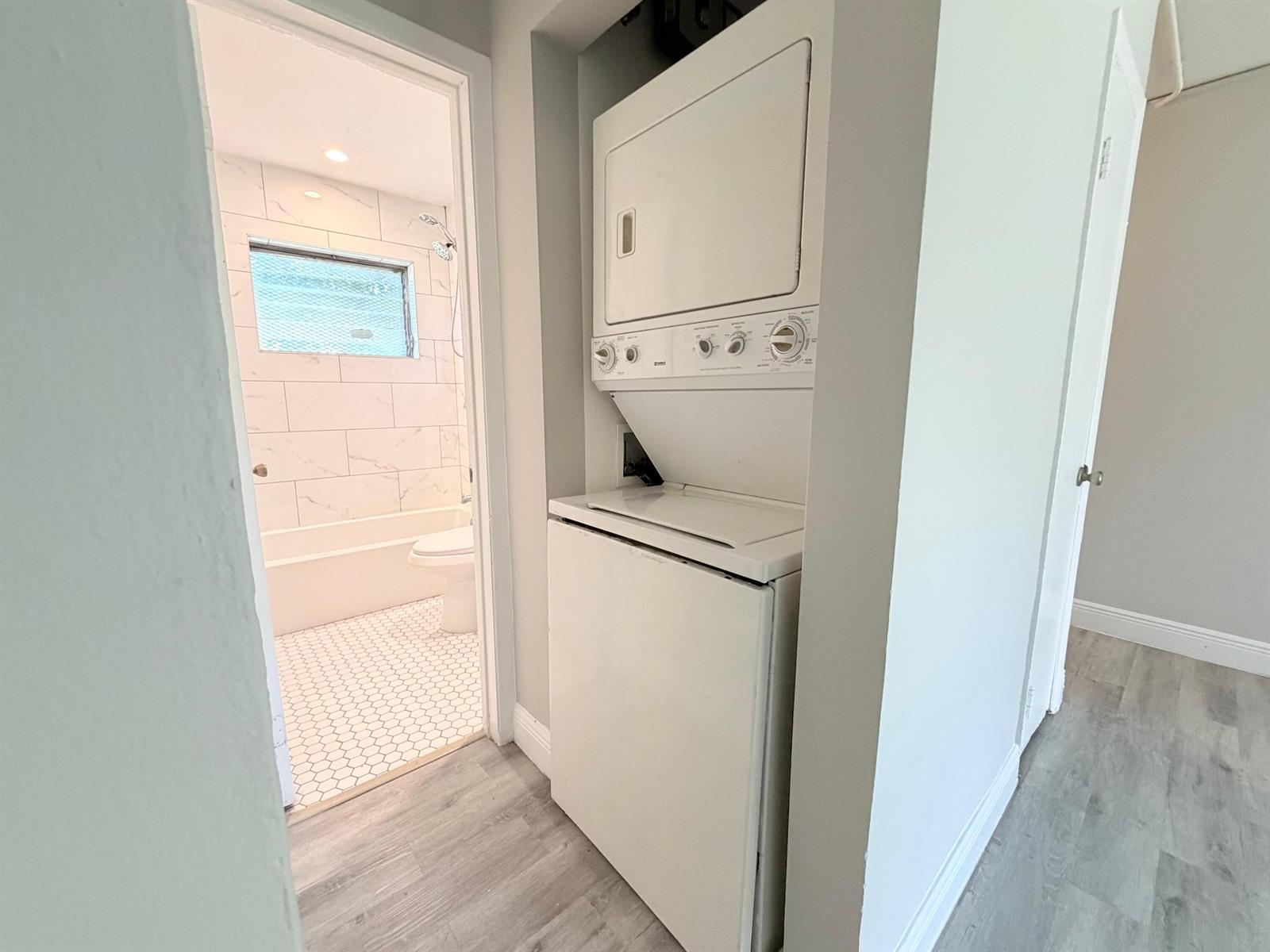 A laundry closet with a stacked washer and dryer sits beside a tiled bathroom — 809 2nd Street # 2, West Palm Beach FL 33401, WEST PALM BEACH, FL