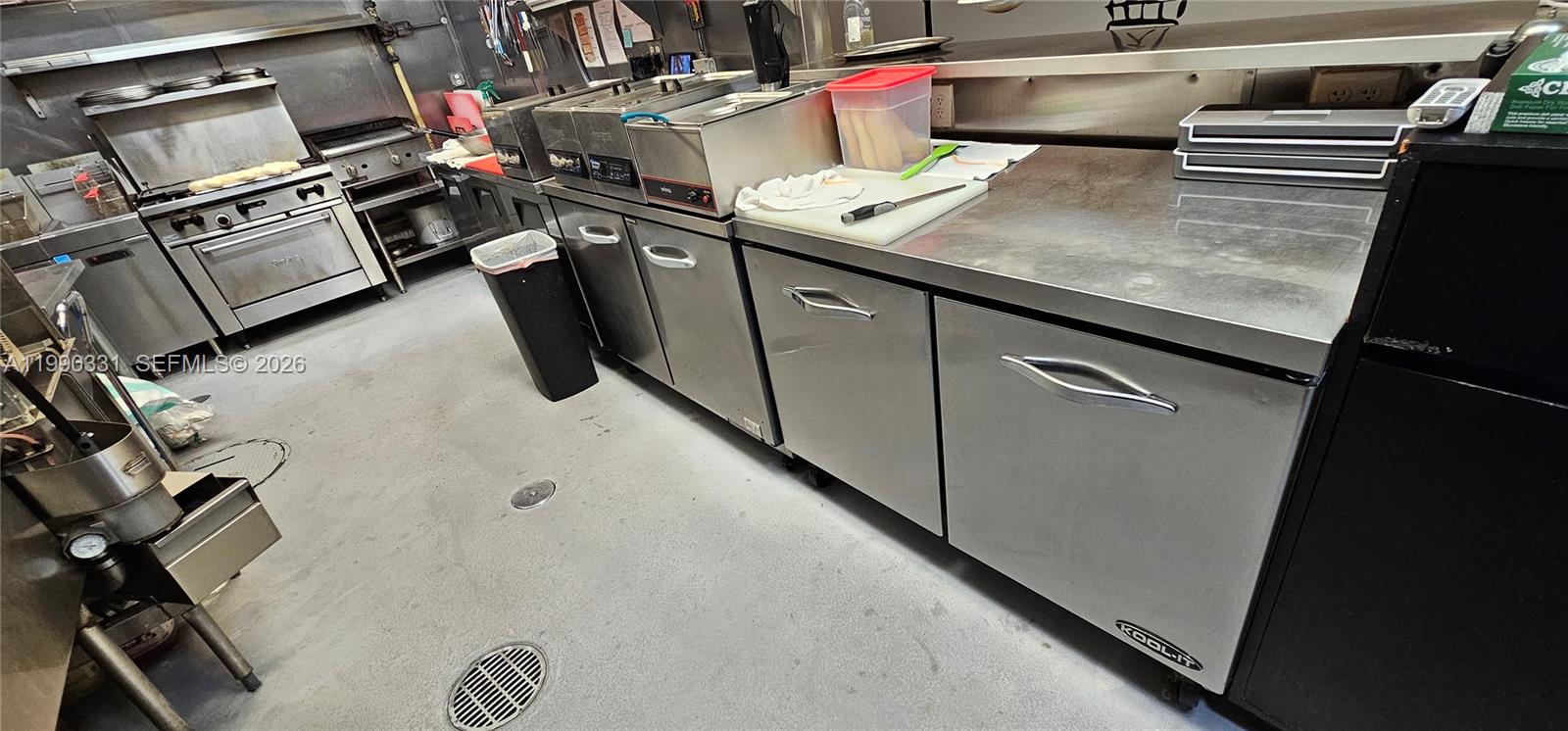 A commercial kitchen features stainless steel appliances, prep counters, and a floor drain — Collins Ave, Sunny Isles Beach FL 33160, SUNNY ISLES BEACH, FL