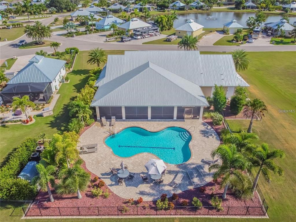 An aerial view shows a house with a metal roof, pool, and patio area — 8306 SW SAND CRANE LOT 87 CIRCLE, ARCADIA, FL