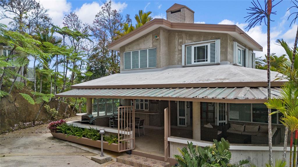A two-story house with a concrete exterior, metal roof, and a covered ground-level patio — PR-184 GUAVATE, CAYEY, PR