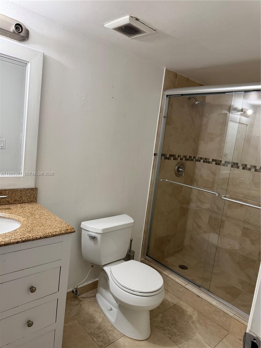 A bathroom features a white vanity, a toilet, and a glass-enclosed tiled shower — 7925 SW 86th St # 923, Miami FL 33143, MIAMI, FL