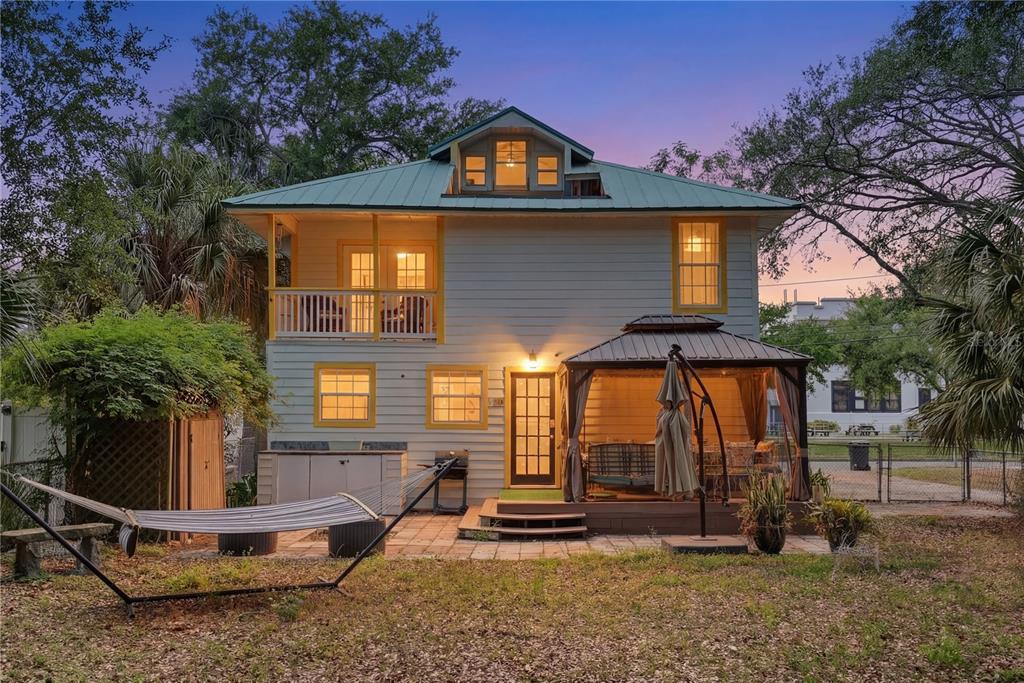 The rear exterior of a two-story house features a patio, gazebo, and a hammock — 516 5TH AVENUE N, SAFETY HARBOR, FL