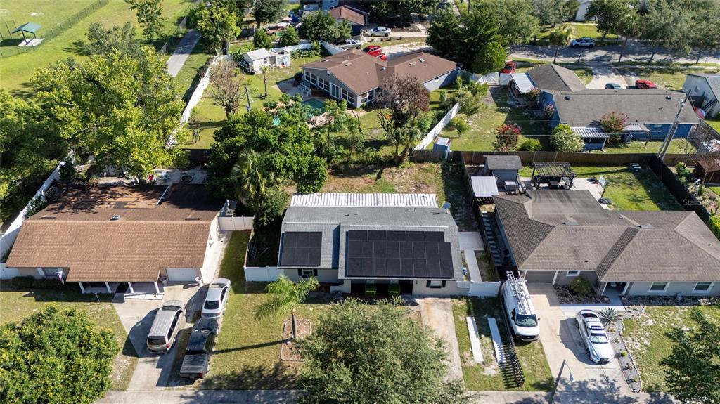 An aerial view shows three suburban houses with driveways, solar panels, and surrounding green lawns — 618 JUPITER WAY, CASSELBERRY, FL