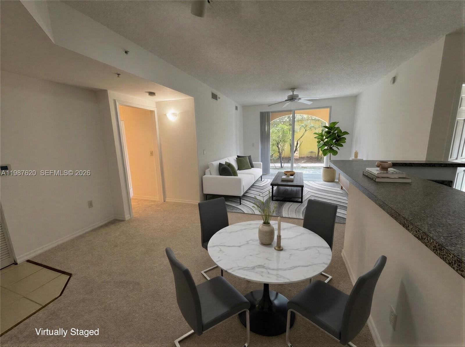 A dining area with a marble table and chairs overlooks a living room with sliding doors — 2351 W Preserve Way # 104, Miramar FL 33025, MIRAMAR, FL