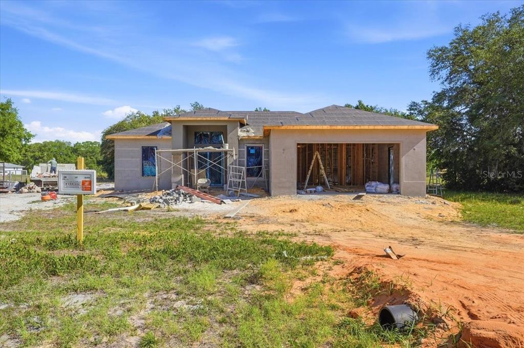 A single-story house under construction with a stucco exterior and an open garage — 2904 OLD STATE ROAD 64 W, AVON PARK, FL