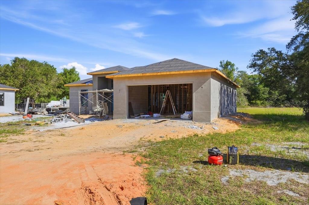 A partially constructed single-story house with a concrete exterior and an open garage bay — 2904 OLD STATE ROAD 64 W, AVON PARK, FL