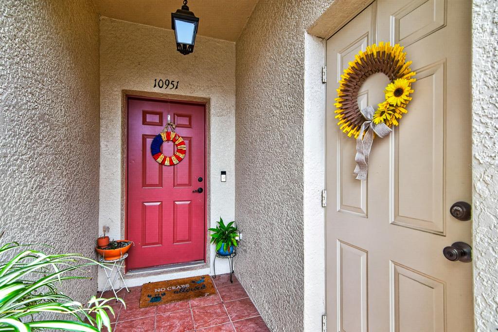 An entryway features a red door with a wreath and a beige door with a wreath — 10951 WINTER CREST DRIVE, RIVERVIEW, FL