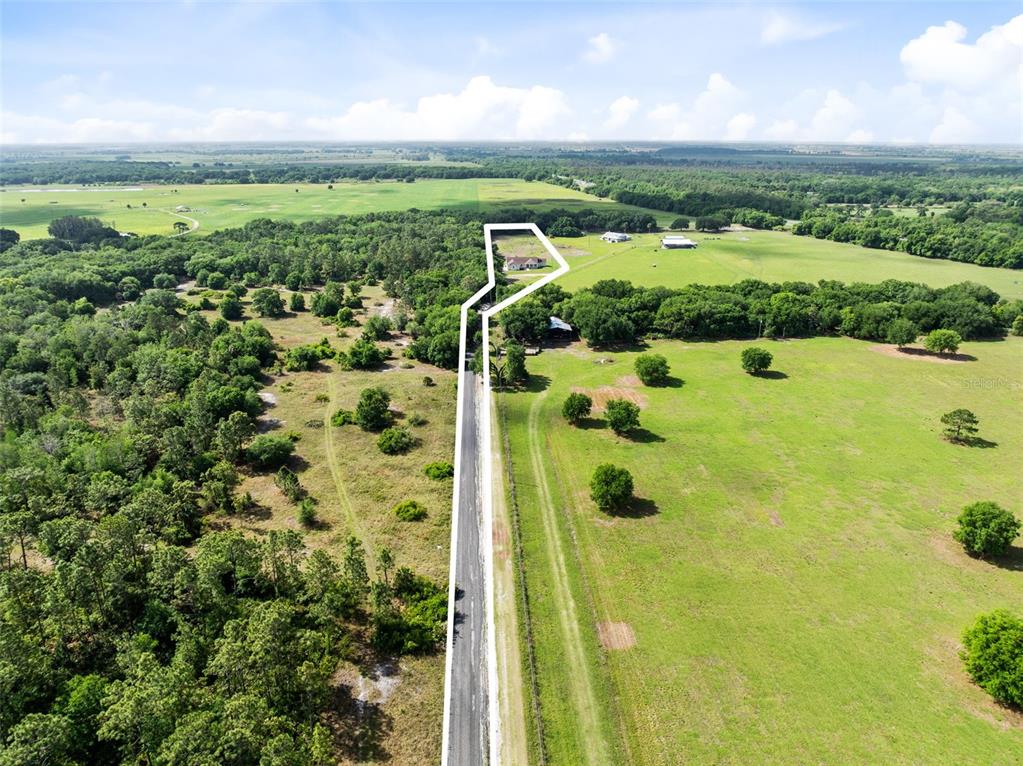 An aerial view shows a rural property with a house, a long driveway, and surrounding fields — 1290 WHITMAN LANE, KENANSVILLE, FL