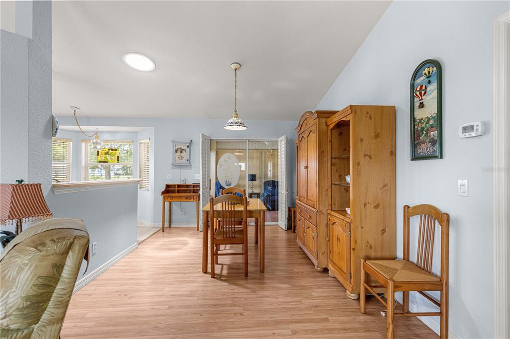 A dining area with wood-look flooring, a wooden table, and a large matching hutch — 6046 SW 98 LOOP, OCALA, FL