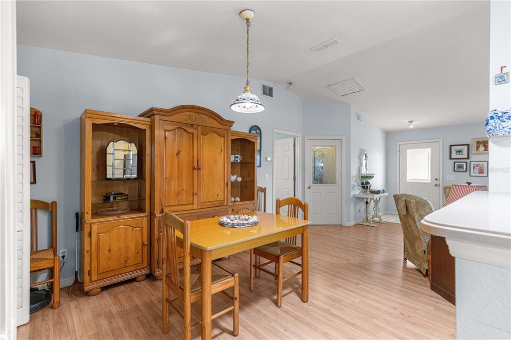 A dining area features a wooden table and hutch set on light wood-look flooring — 6046 SW 98 LOOP, OCALA, FL