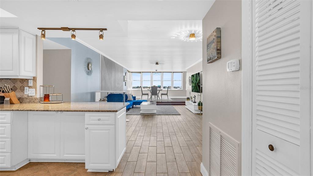 A kitchen with white cabinets, granite countertops, stainless steel appliances, and tile flooring — 5130 BRITTANY DRIVE S UNIT 507, ST PETERSBURG, FL