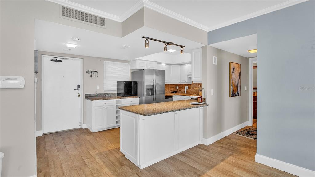 A view from a kitchen island looking into an open-concept living and dining area — 5130 BRITTANY DRIVE S UNIT 507, ST PETERSBURG, FL