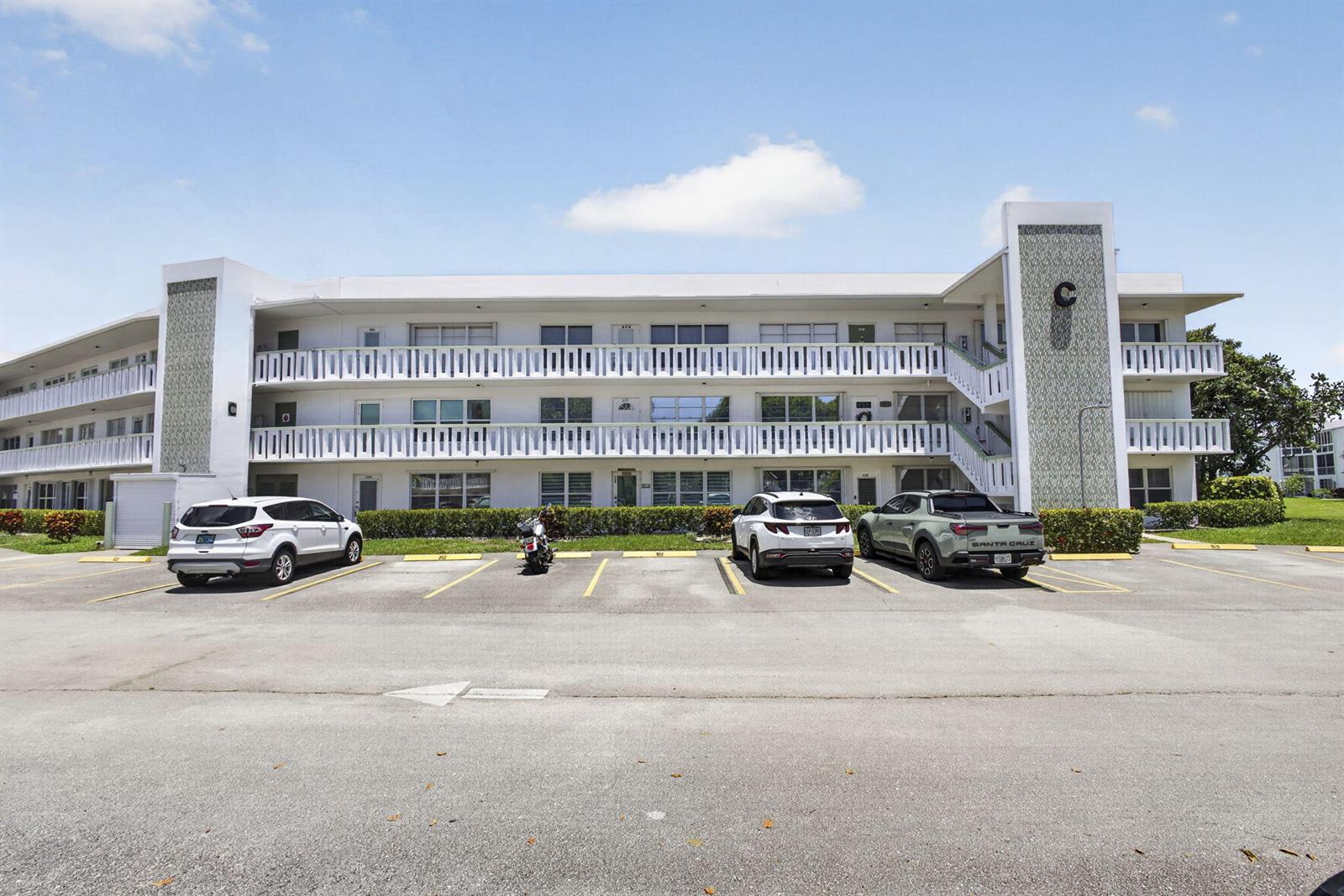 A three-story apartment building with a parking lot in front and a large letter C — 307 Wellington C, West Palm Beach FL 33417, WEST PALM BEACH, FL