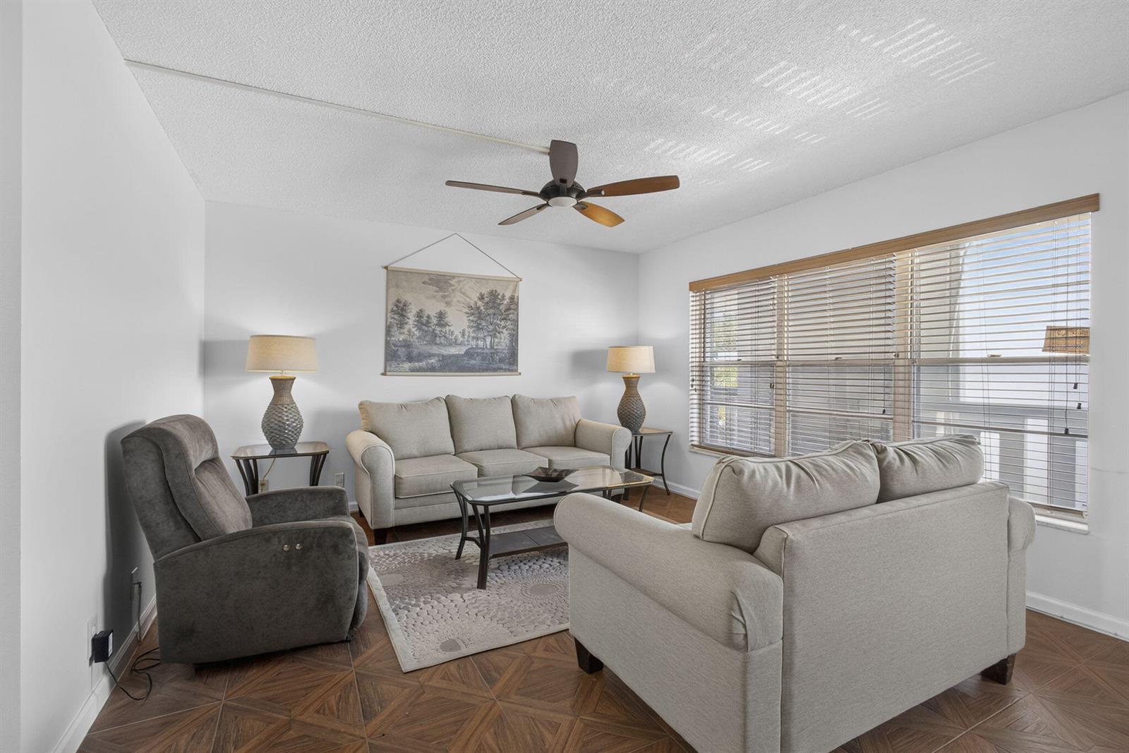 A living room features a sofa, loveseat, recliner, coffee table, and tiled flooring — 307 Wellington C, West Palm Beach FL 33417, WEST PALM BEACH, FL