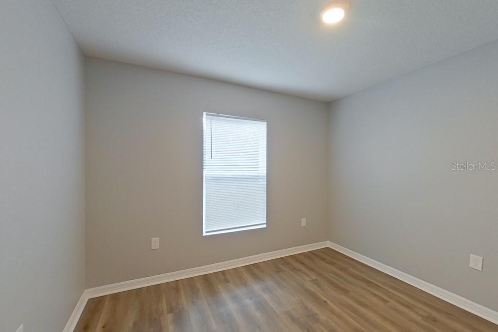 An empty bedroom features light gray walls, wood-look flooring, and a single window with blinds — 2907 W CAMILO DRIVE, CITRUS SPRINGS, FL