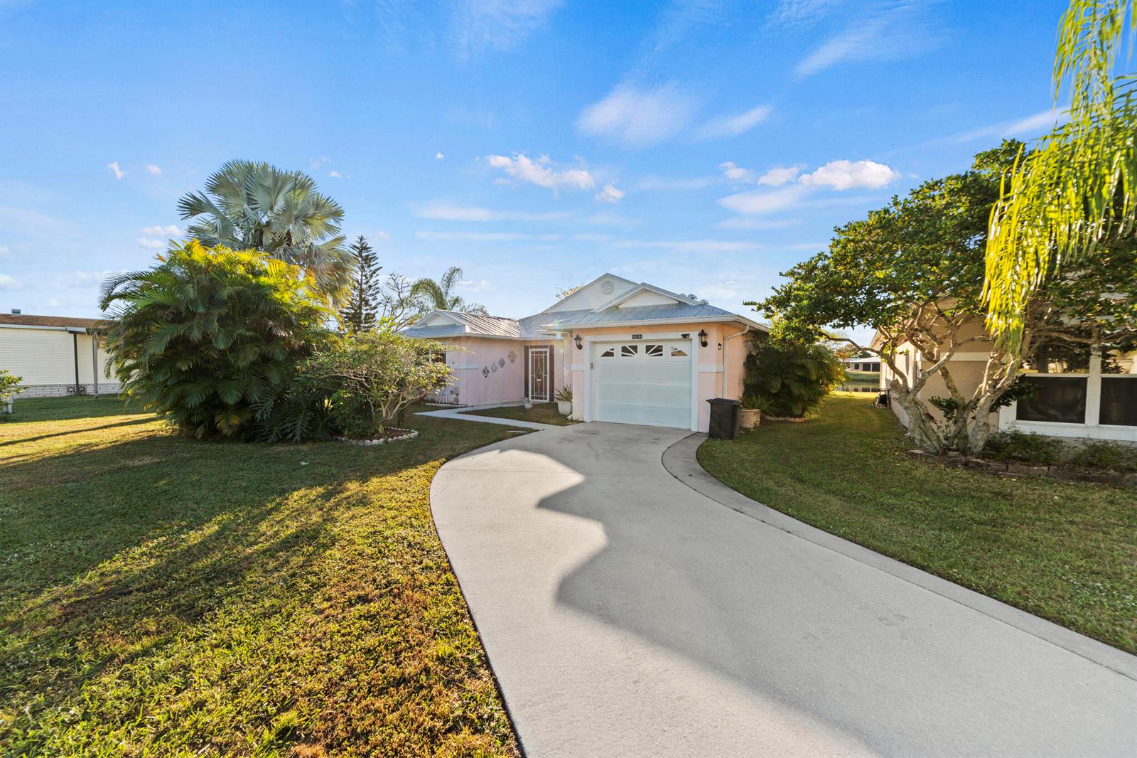 A pink single-story house with a white garage door and a curved concrete driveway — 14191 Cisne Circle, Fort Pierce FL 34951, FORT PIERCE, FL