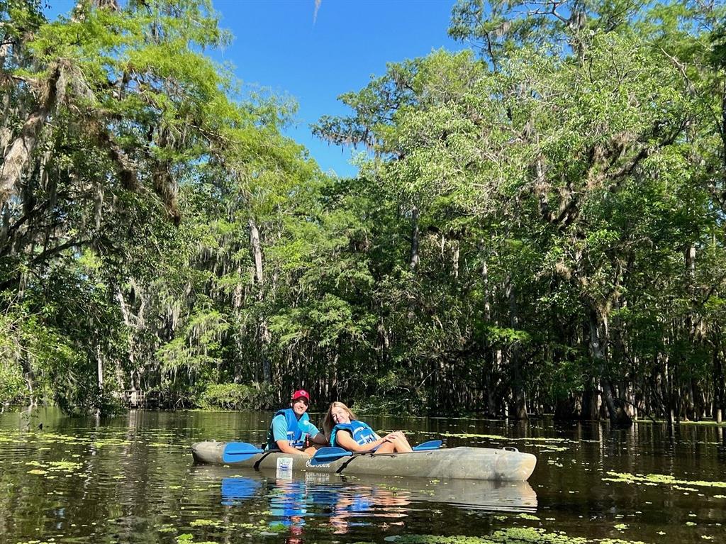 A man and a woman in life jackets kayak through a scenic, tree-lined swamp — lot 12 NW 70 CIRCLE, CHIEFLAND, FL
