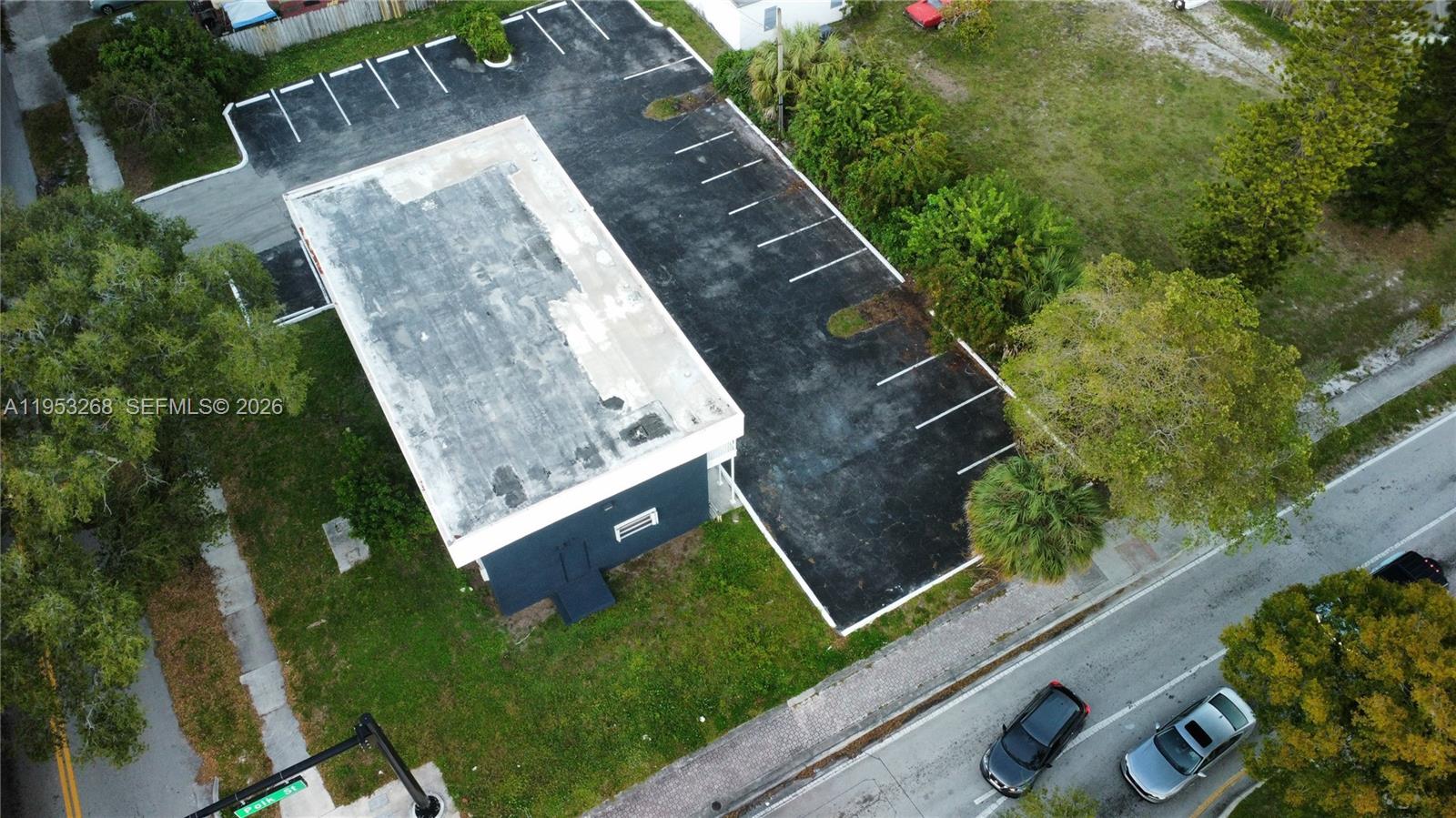 An aerial view shows a rectangular building with a flat roof and an adjacent parking lot — 2555 Polk St, Hollywood FL 33020, HOLLYWOOD, FL