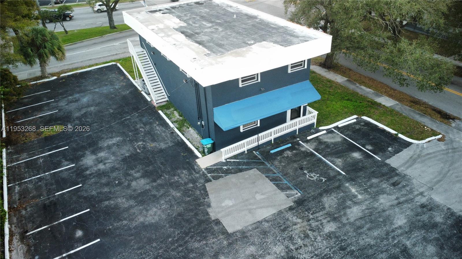 An aerial view shows a two-story dark blue building with a flat roof and parking lot — 2555 Polk St, Hollywood FL 33020, HOLLYWOOD, FL