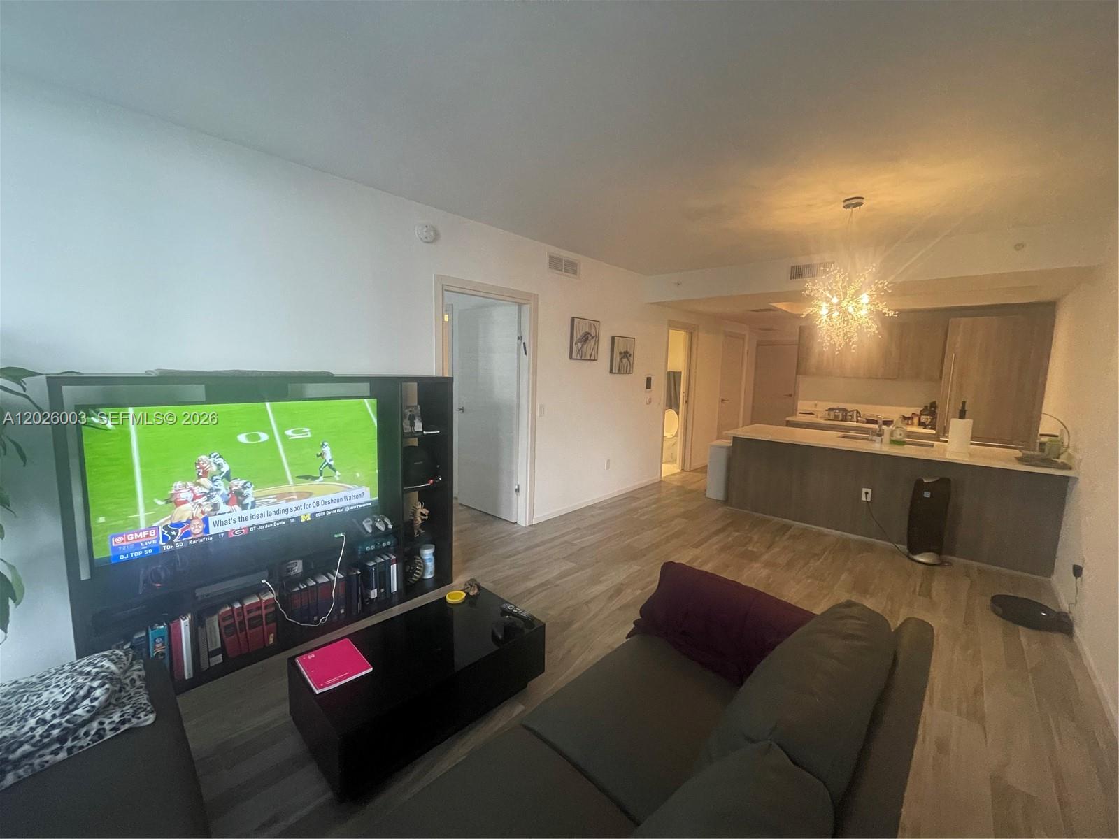 A living room with a television, a sofa, and an open kitchen with a breakfast bar — 801 S Miami Ave # 2207, Miami FL 33130, MIAMI, FL