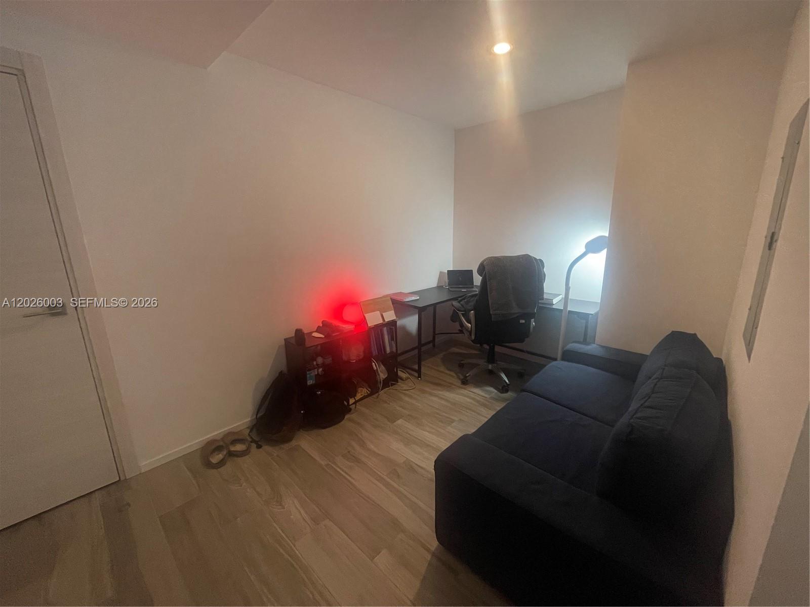 A small home office features a desk, an office chair, a sofa, and wood-look flooring — 801 S Miami Ave # 2207, Miami FL 33130, MIAMI, FL