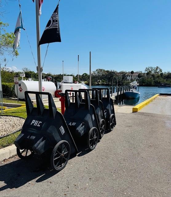 A row of black utility carts sits on a paved area near a boat dock — 1780 PHILLIPPI SHORES DRIVE UNIT A3-22, SARASOTA, FL