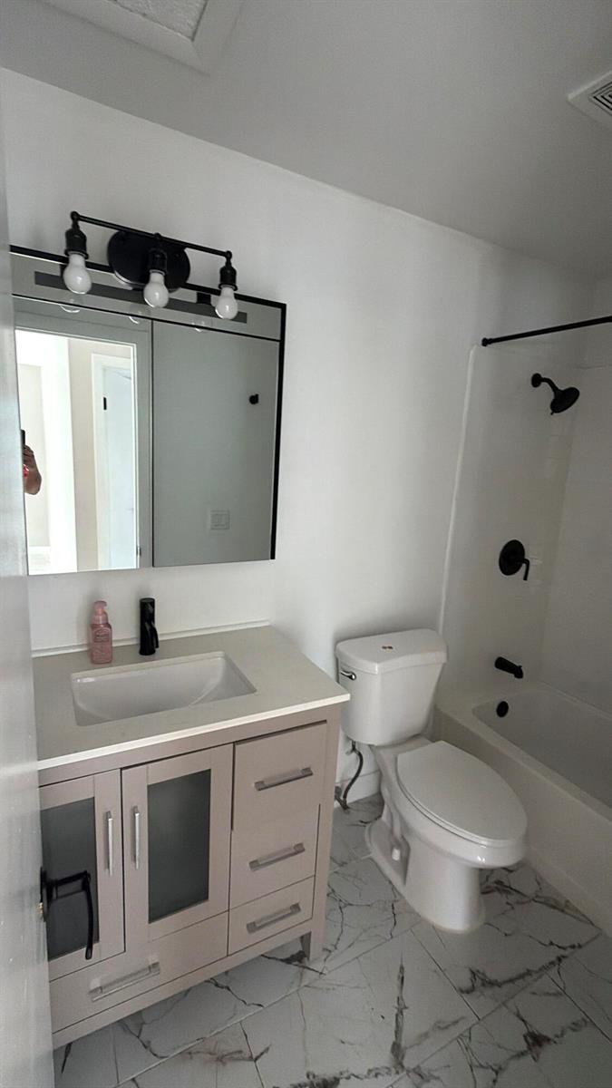 A bathroom features a vanity with a light-colored cabinet, a mirror, and a tub-shower combo — 47 SE 13th Street # 2, Dania Beach FL 33004, DANIA BEACH, FL