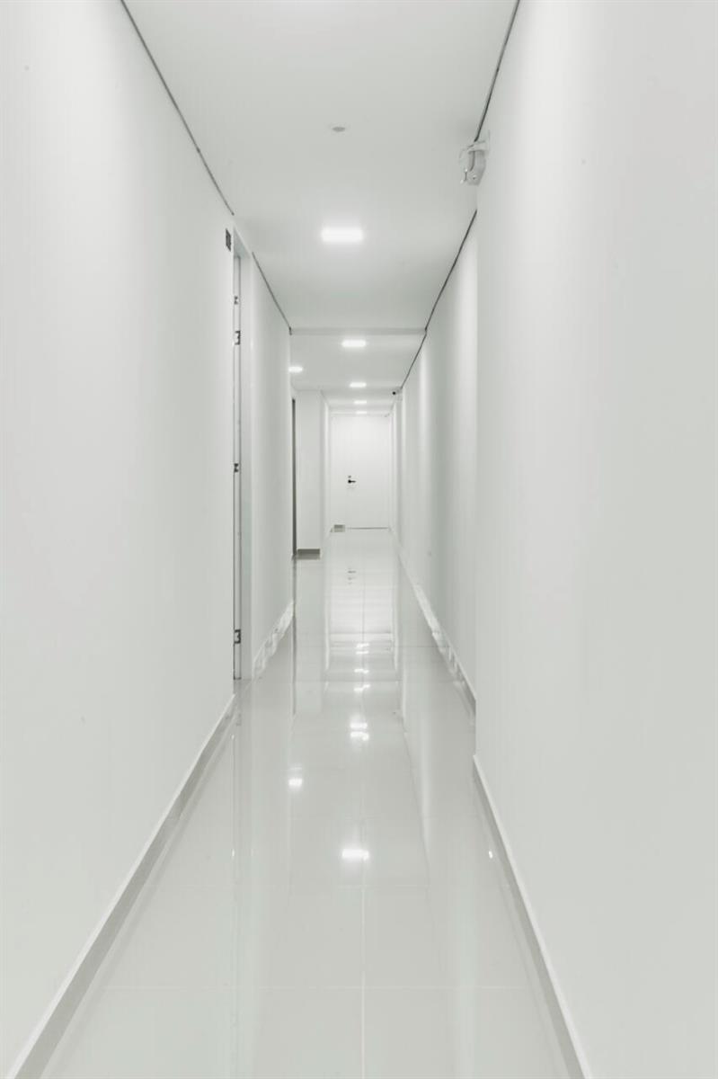 A long, narrow hallway with white walls, recessed ceiling lights, and glossy white tile flooring — Carrera 47 Numero 64 45, 00000, FL