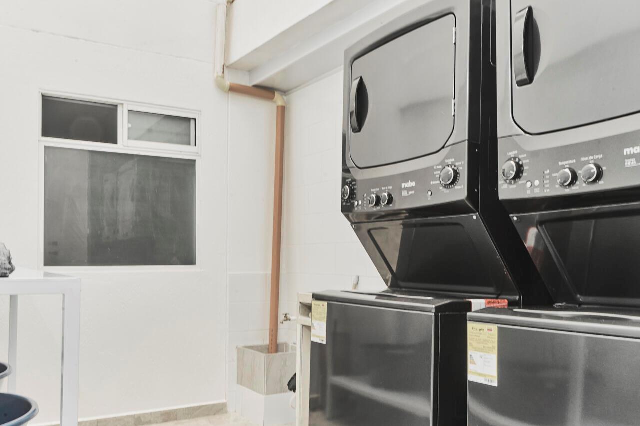 A laundry room features two stacked black Mabe washer-dryer units and a window — Carrera 47 Numero 64 45, 00000, FL