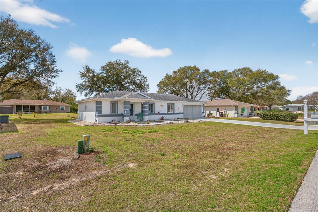 A single-story house with a white exterior, gray trim, and a concrete driveway — 6196 SW 101ST PLACE, OCALA, FL