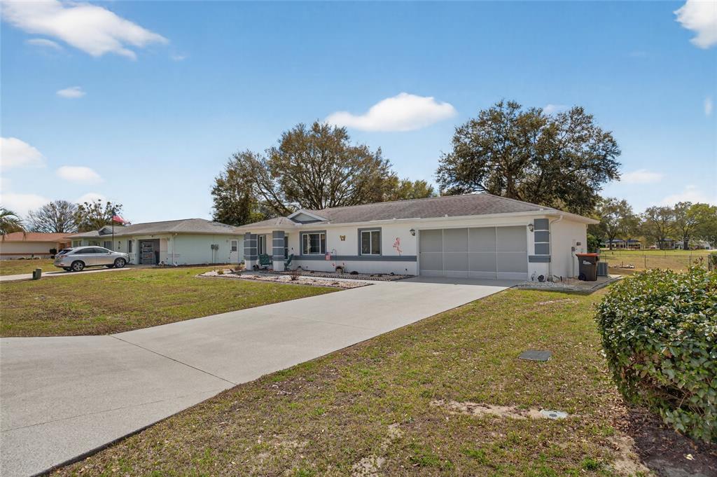 A single-story house with a white exterior, gray trim, and a concrete driveway — 6196 SW 101ST PLACE, OCALA, FL