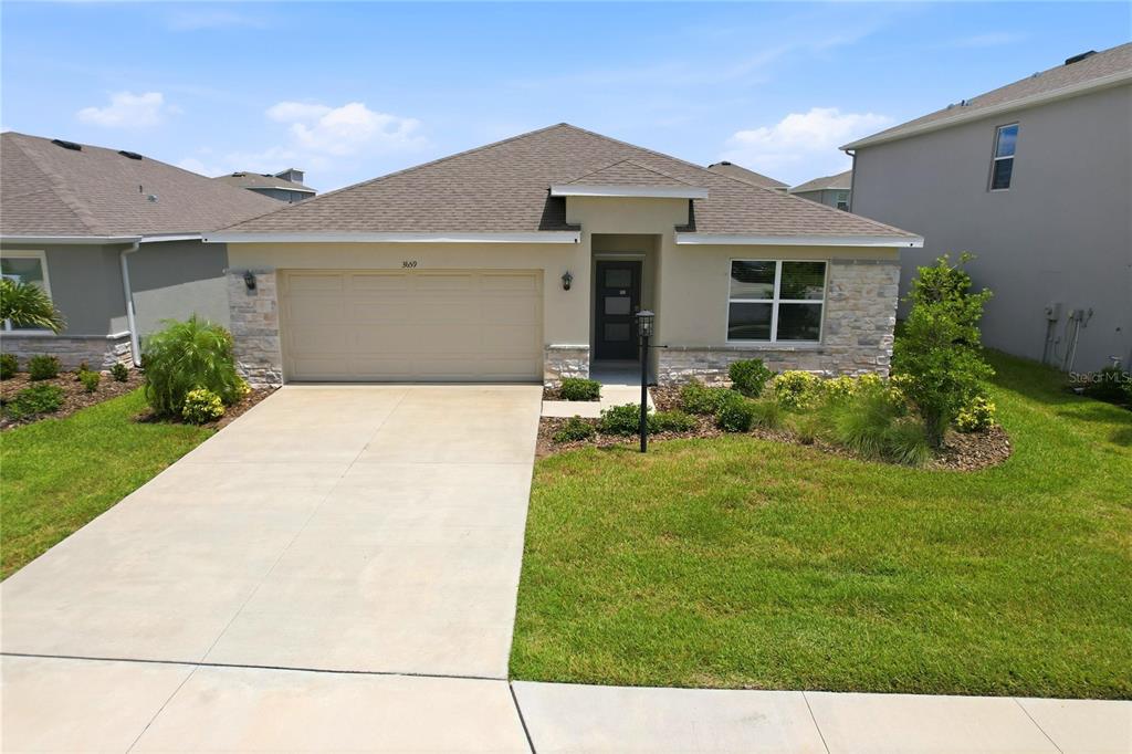 A single-story house features a tan stucco exterior, stone accents, and a two-car garage — 3659 HATCHERY WAY, BRADENTON, FL