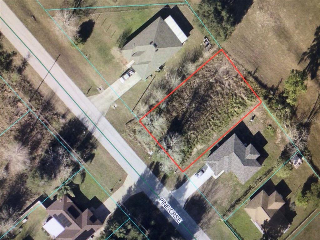 An aerial view shows a vacant, rectangular lot outlined in red between two residential houses — 0 PINE COURSE, OCALA, FL