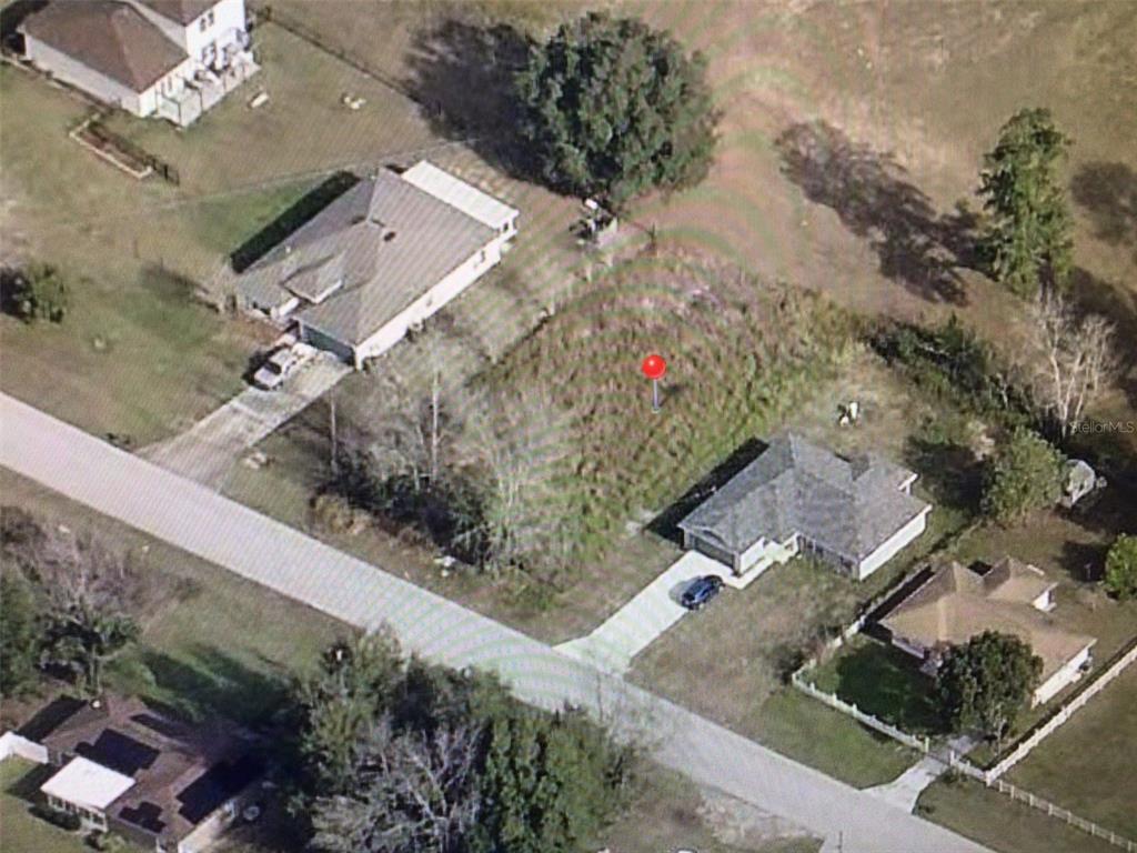 An aerial view shows a vacant lot situated between two single-family residential homes — 0 PINE COURSE, OCALA, FL
