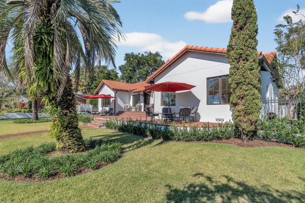 A white house with a red tile roof features a patio with outdoor furniture — 631 LAKE CATHERINE DRIVE, MAITLAND, FL