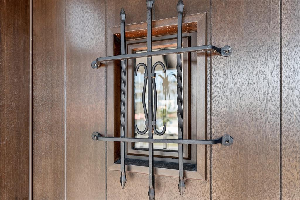 A close-up view of a brown wooden door featuring a small window with iron bars — 631 LAKE CATHERINE DRIVE, MAITLAND, FL